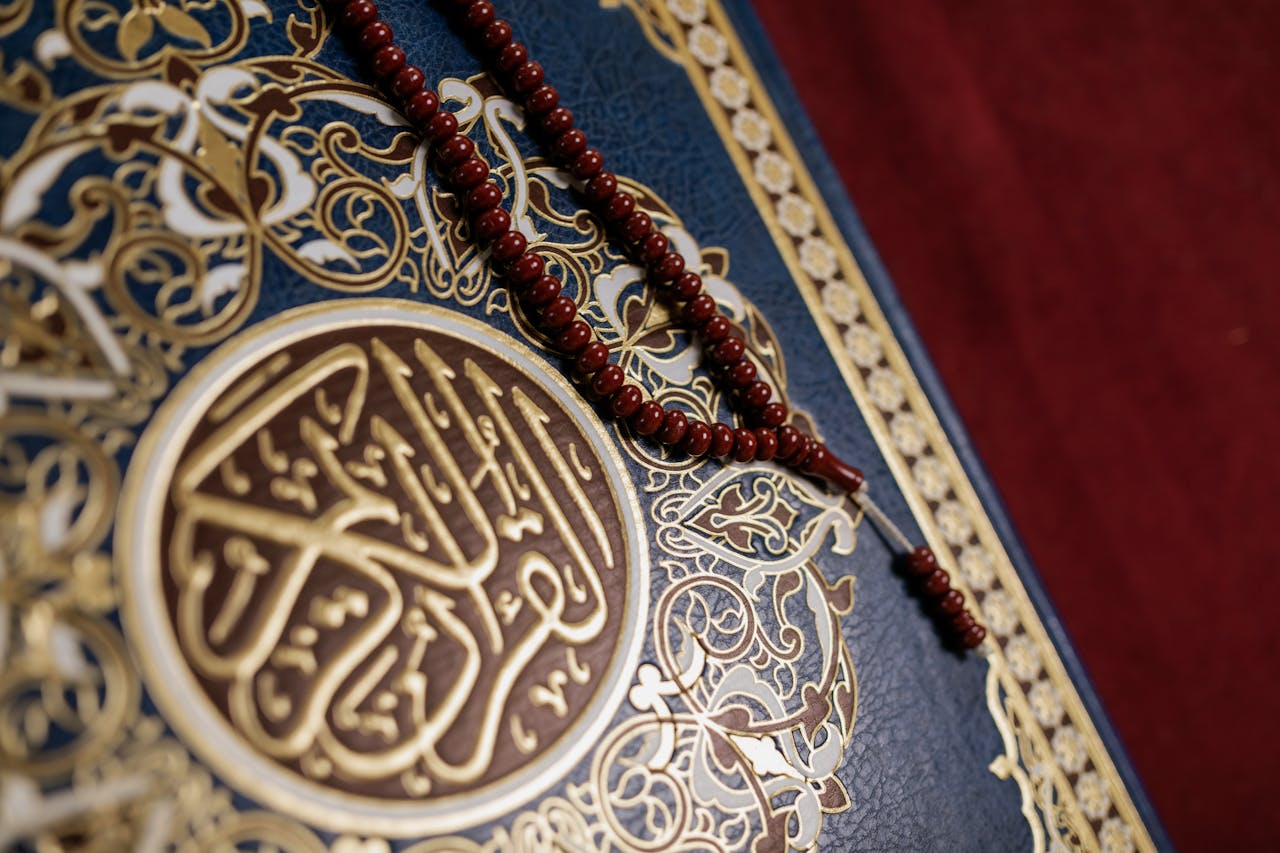 An ornate Quran cover adorned with prayer beads, showcasing luxurious design elements.